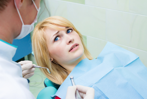 woman in dental chair scared of root canal due to misconceptions about treatment