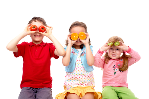 portrait of healthy children with fruits over eyes