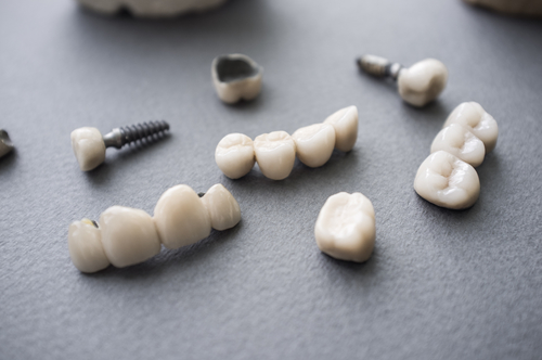 Ceramic dentures and crowns on gray background