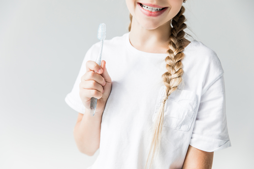 girl smiling holding tooth brush