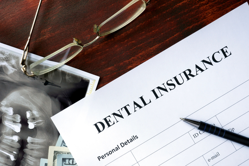 dental insurance form and x-ray of teeth on desk