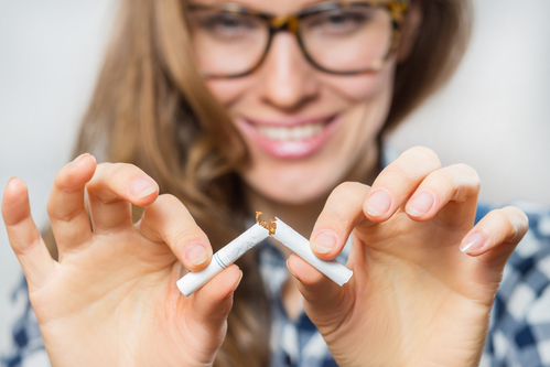 woman breaking cigarette in half to help prevent oral cancer
