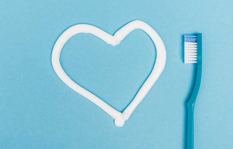 toothbrush next to toothpaste heart