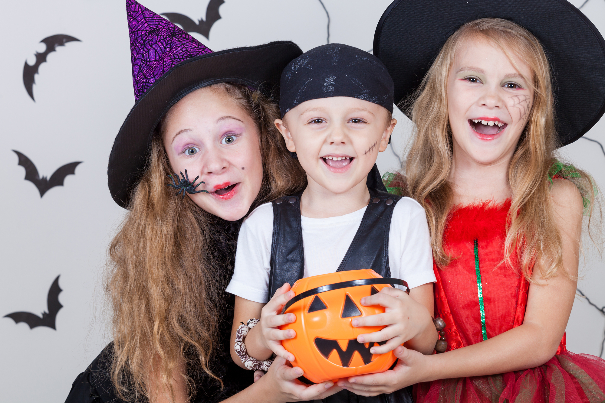 Happy kids smiling and trick or treating with healthy teeth.