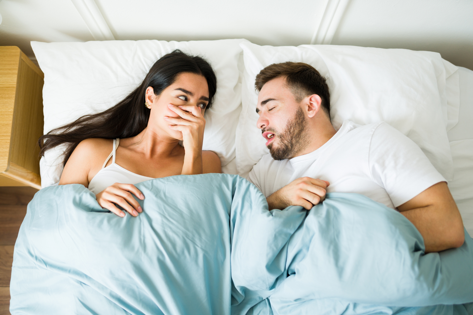 Woman smelling her partner's morning breath.