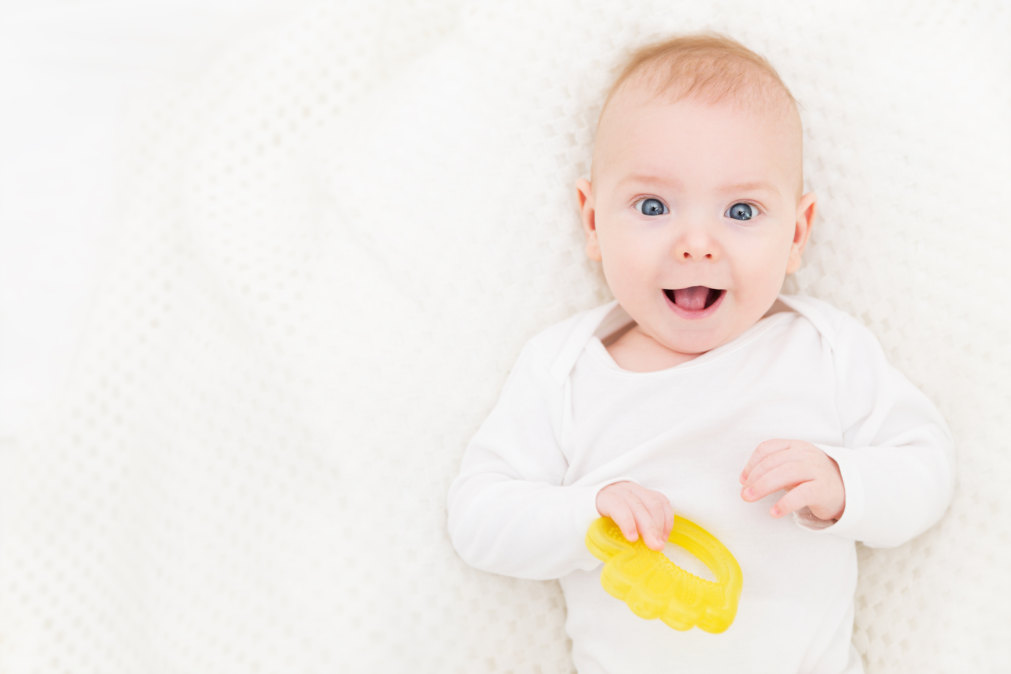 Happy baby with teething toy. 