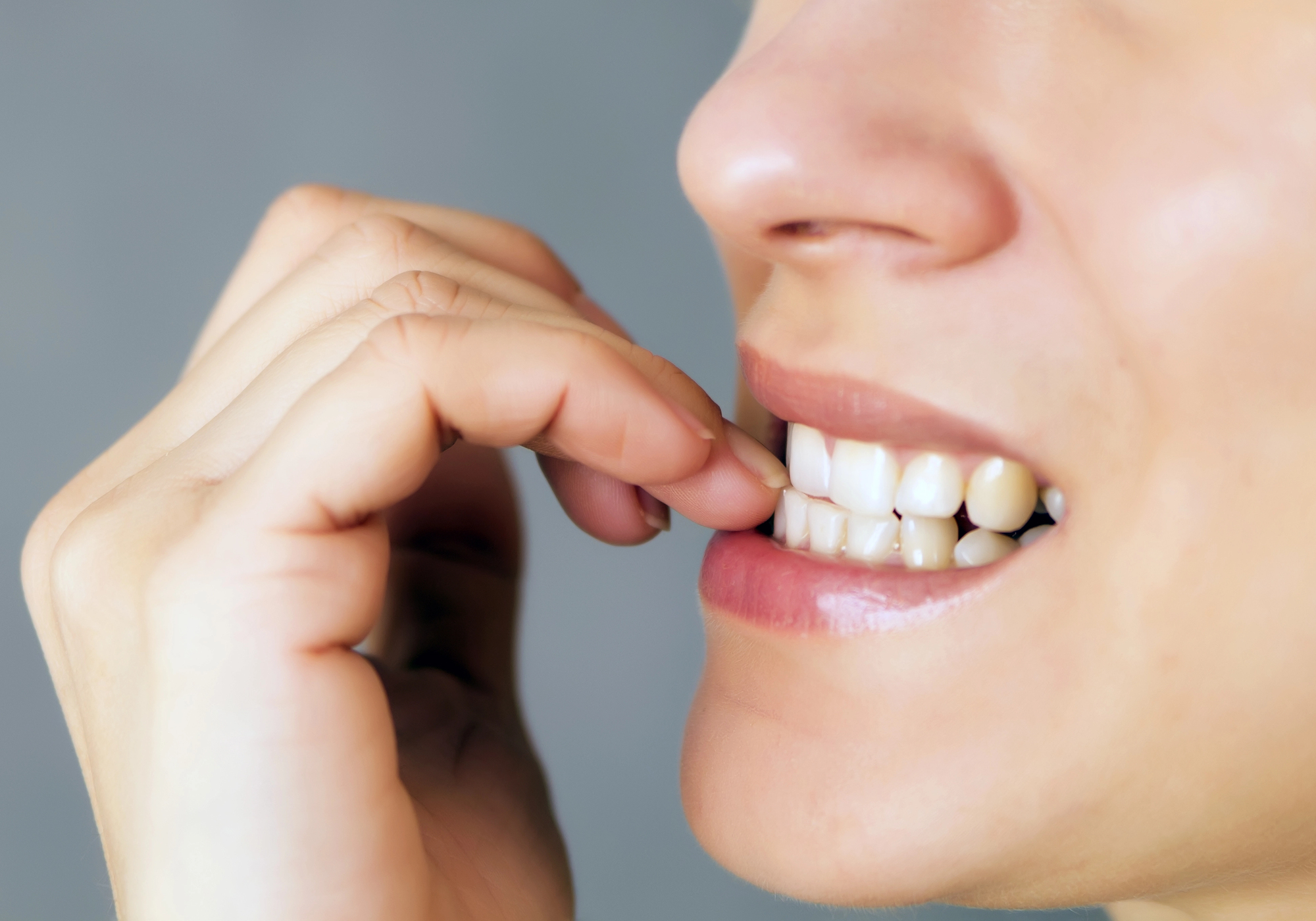 Teeth biting nails. 