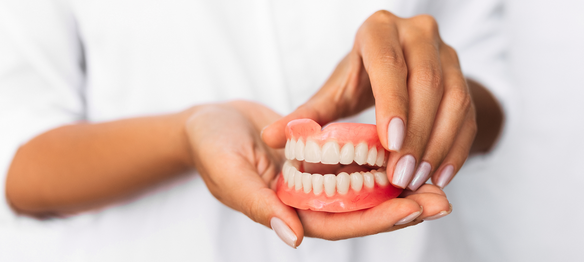 Dentist holding a set of dentures.