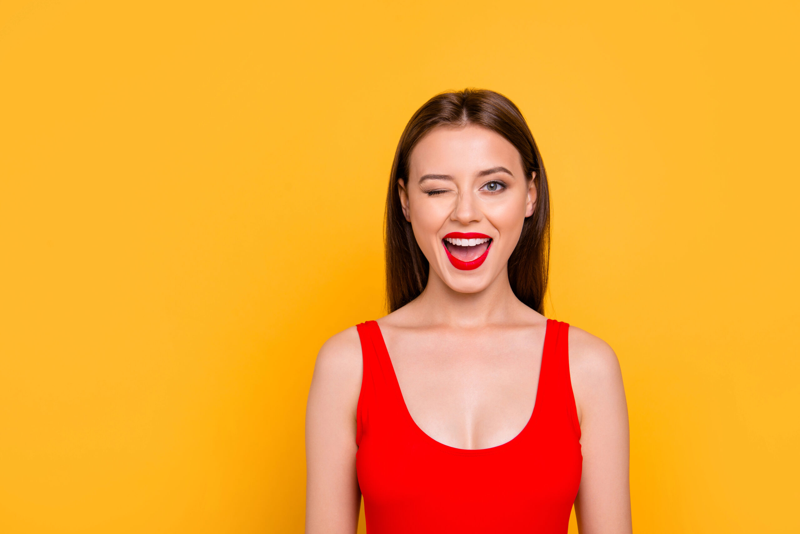 Woman with white healthy teeth winking.