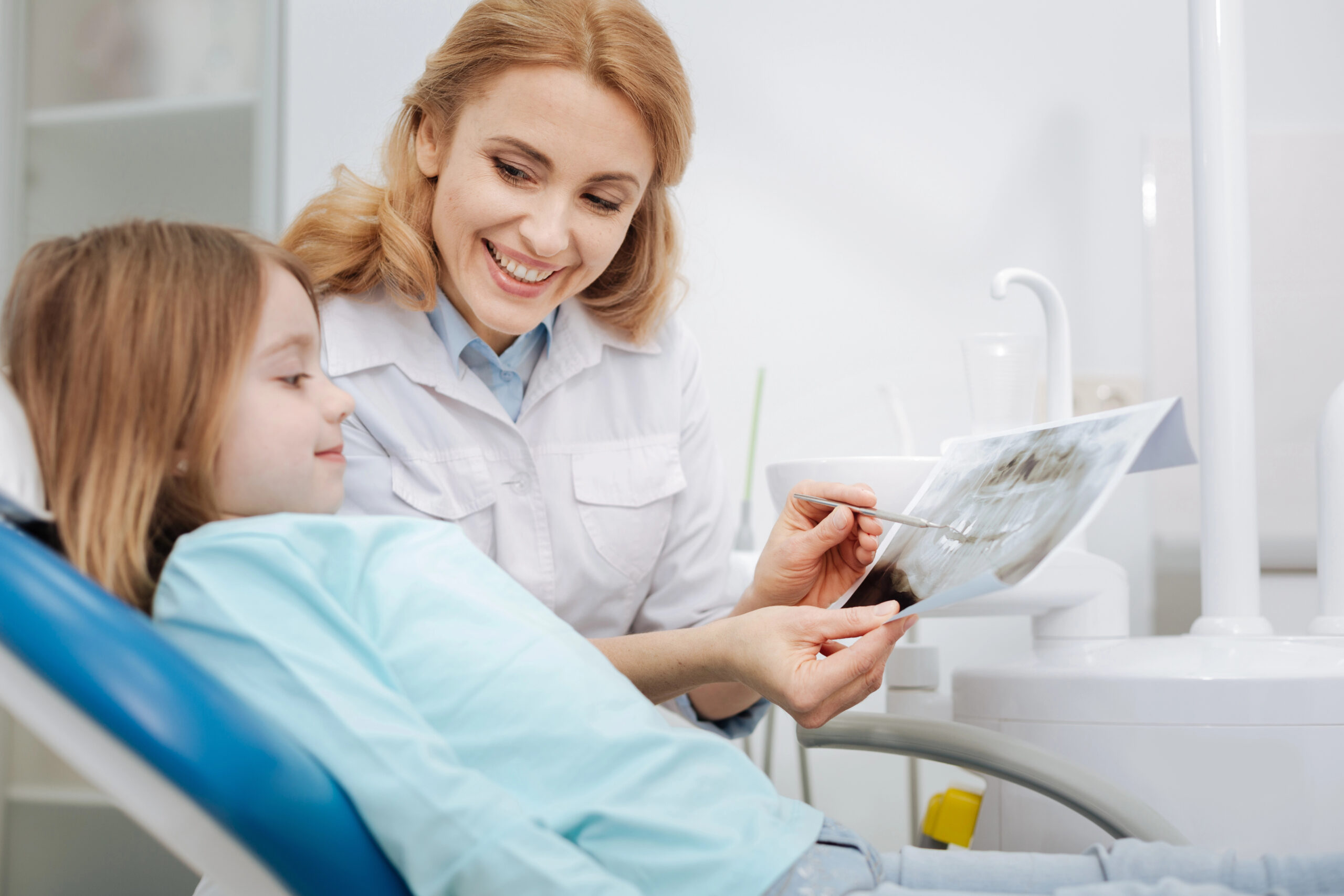 Pediatric dentist showing child dental x-rays. 